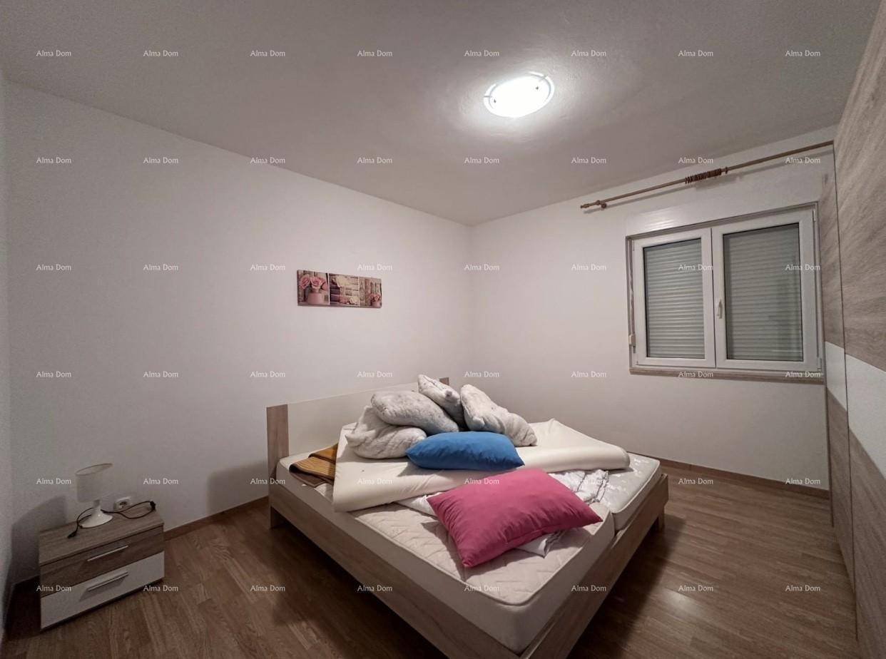 Helles Schlafzimmer mit Doppelbett, Nachttischen und einem Fenster, einfach eingerichtet.