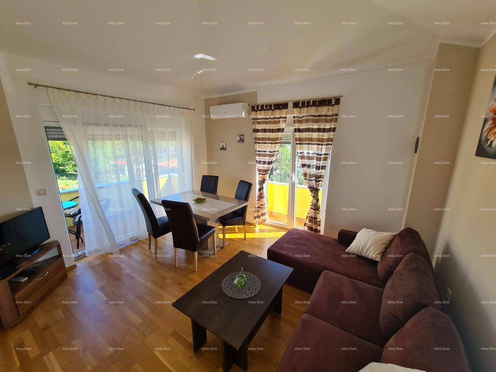 Heller Wohn-Essbereich mit rotem Sofa, Esstisch und Zugang zu einem sonnigen Balkon.