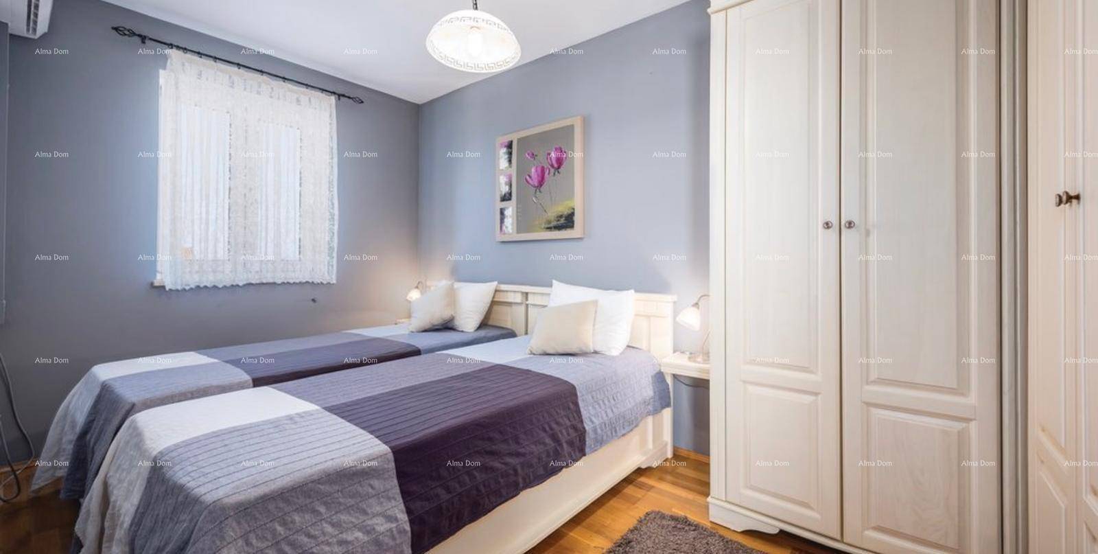 Schlafzimmer mit zwei Einzelbetten, grauen Wänden und einem weißen Kleiderschrank.