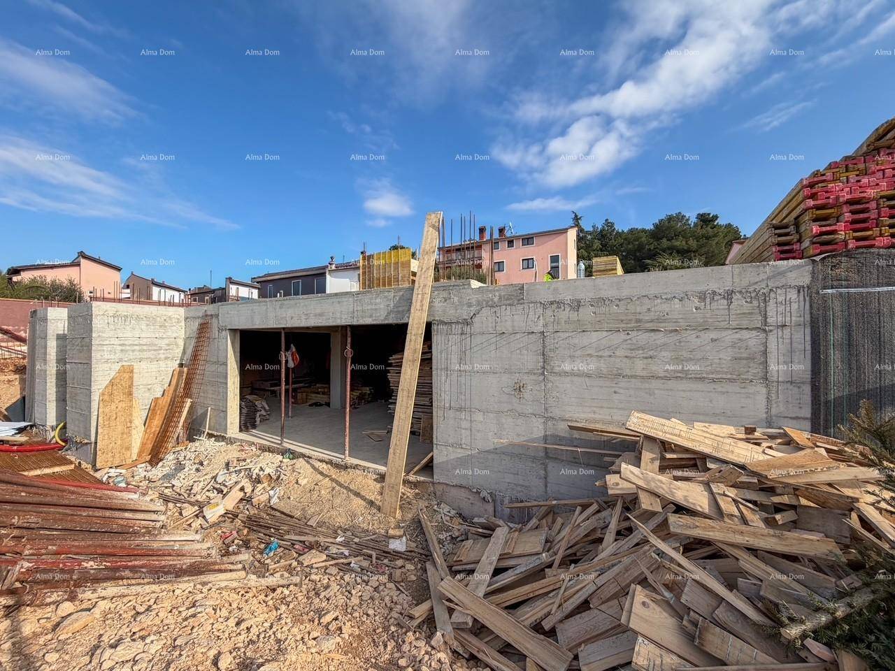 Baustelle mit Betonwänden und Baumaterialien, die den Baufortschritt des Gebäudes zeigen.