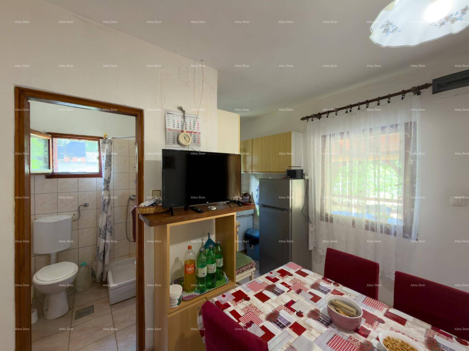 Wohnküche mit Esstisch und Blick auf das angrenzende Badezimmer, praktisch und funktional.