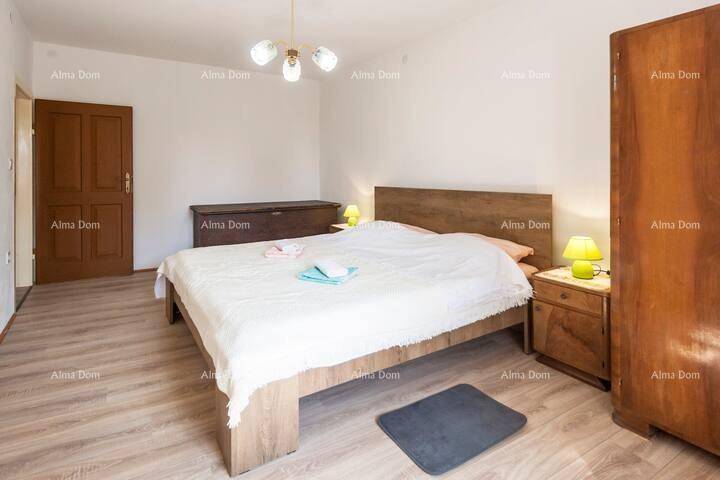 Geräumiges Schlafzimmer mit Doppelbett, Holzschrank und hellem Laminatboden.