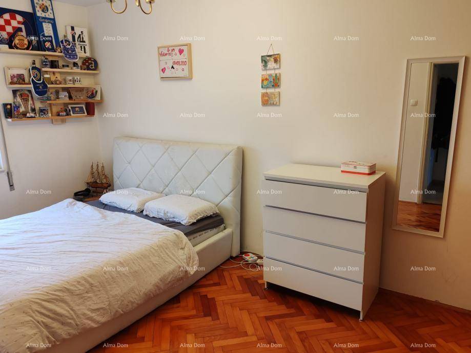 Schlafzimmer mit Doppelbett, Kommode und klassischem Parkettboden.