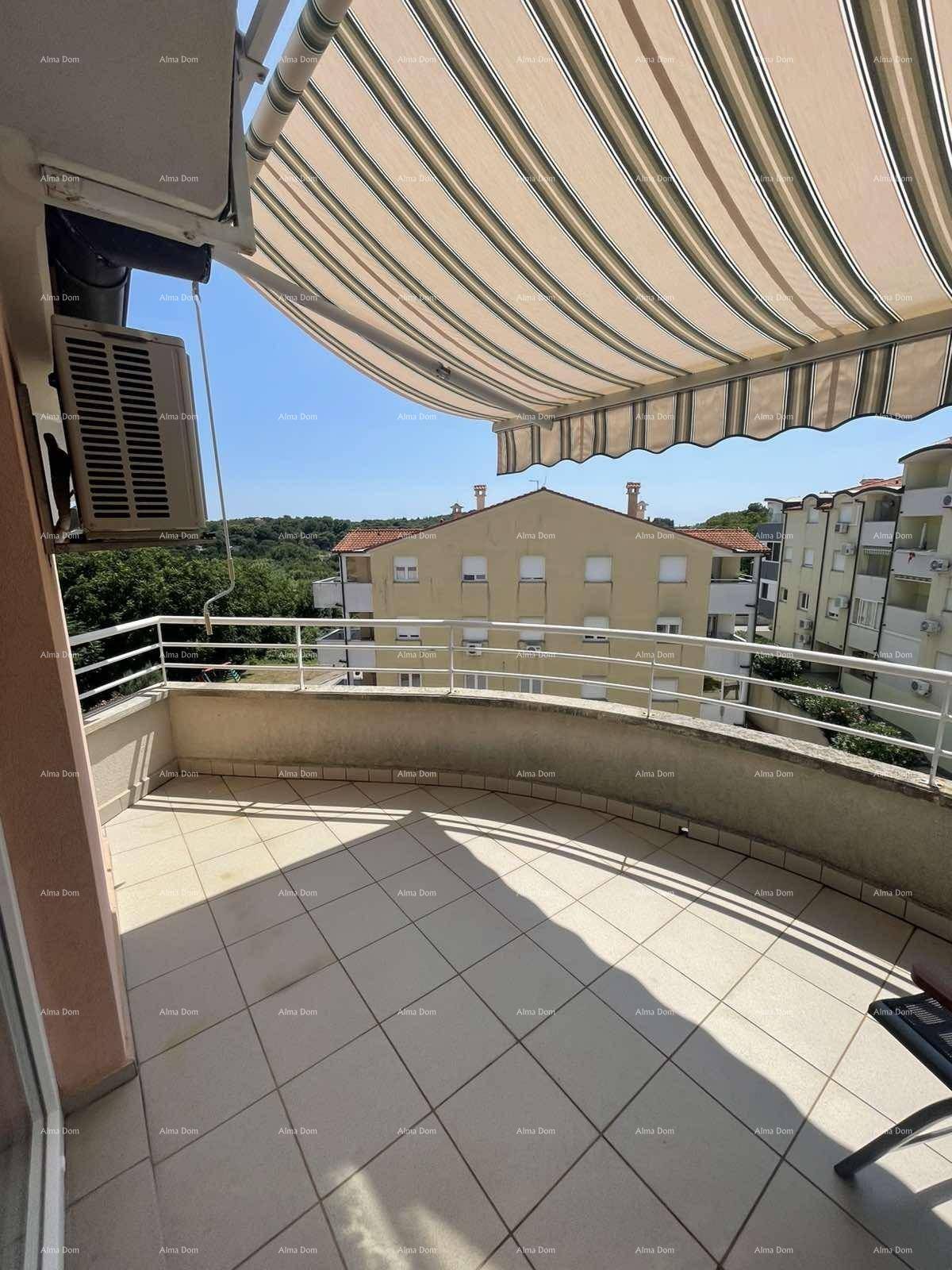 Geräumiger Balkon mit Fliesenboden, Markise und Blick auf die Umgebung.