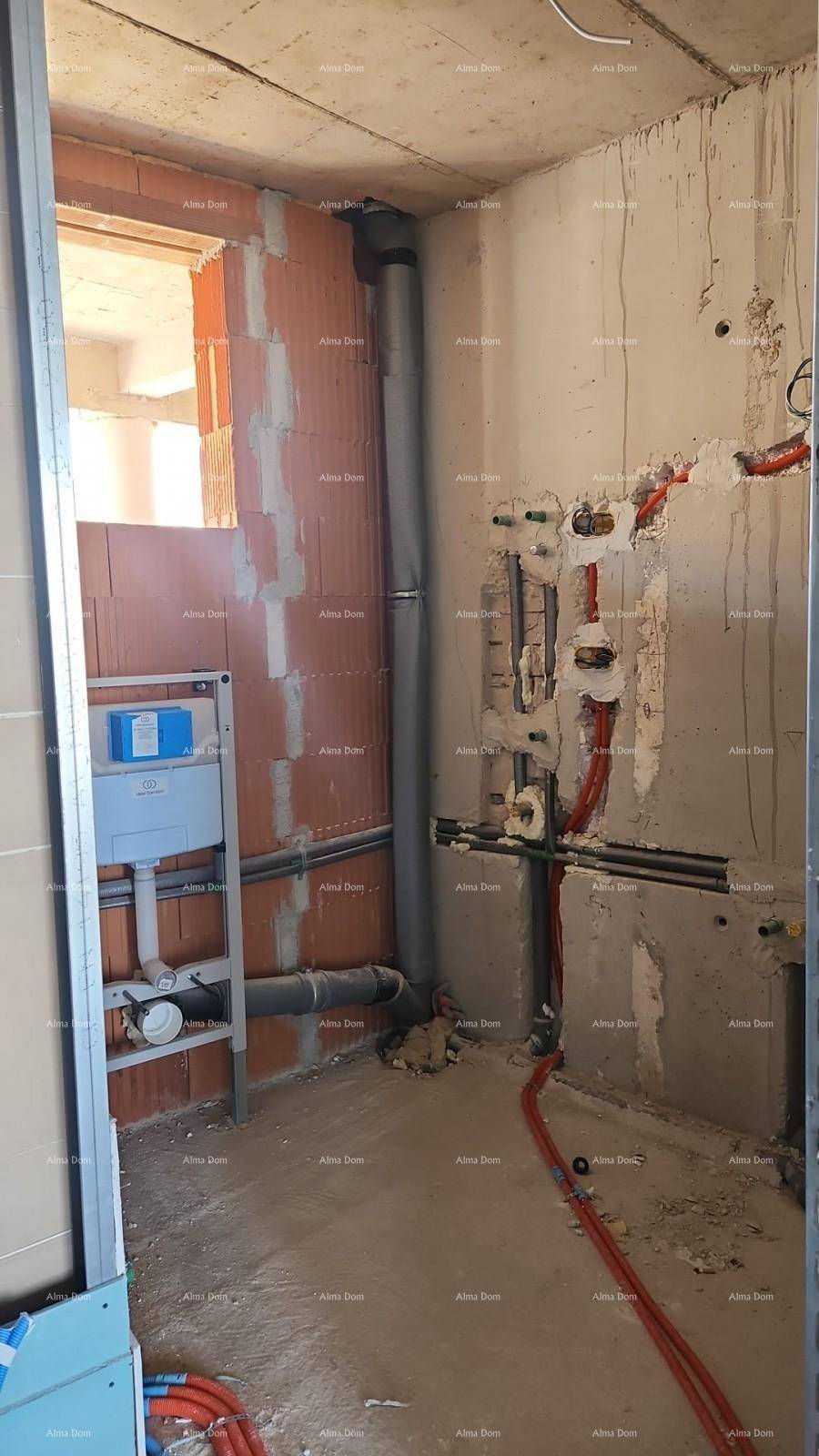 Badezimmer im Rohbau mit sichtbaren Sanitärinstallationen und Ziegelwänden.
