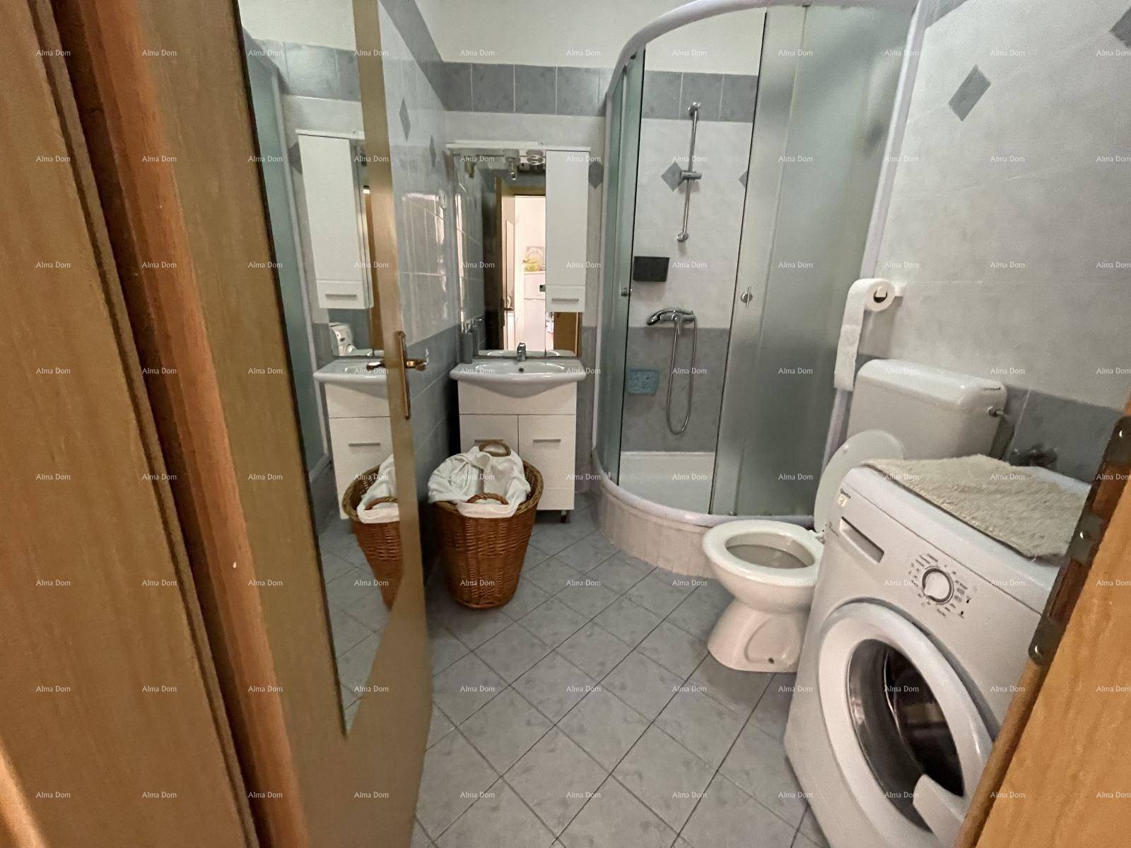 Badezimmer mit Duschkabine, WC, Waschbecken und Waschmaschine, hell gefliest.