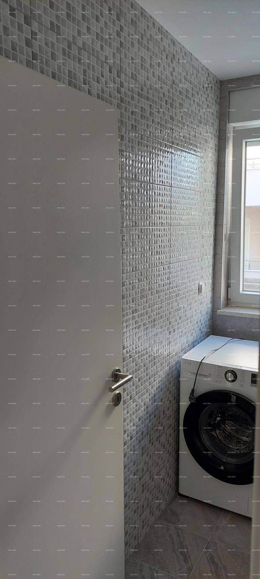 Waschbereich mit Waschmaschine und dekorativen Wandfliesen in hellem Design.