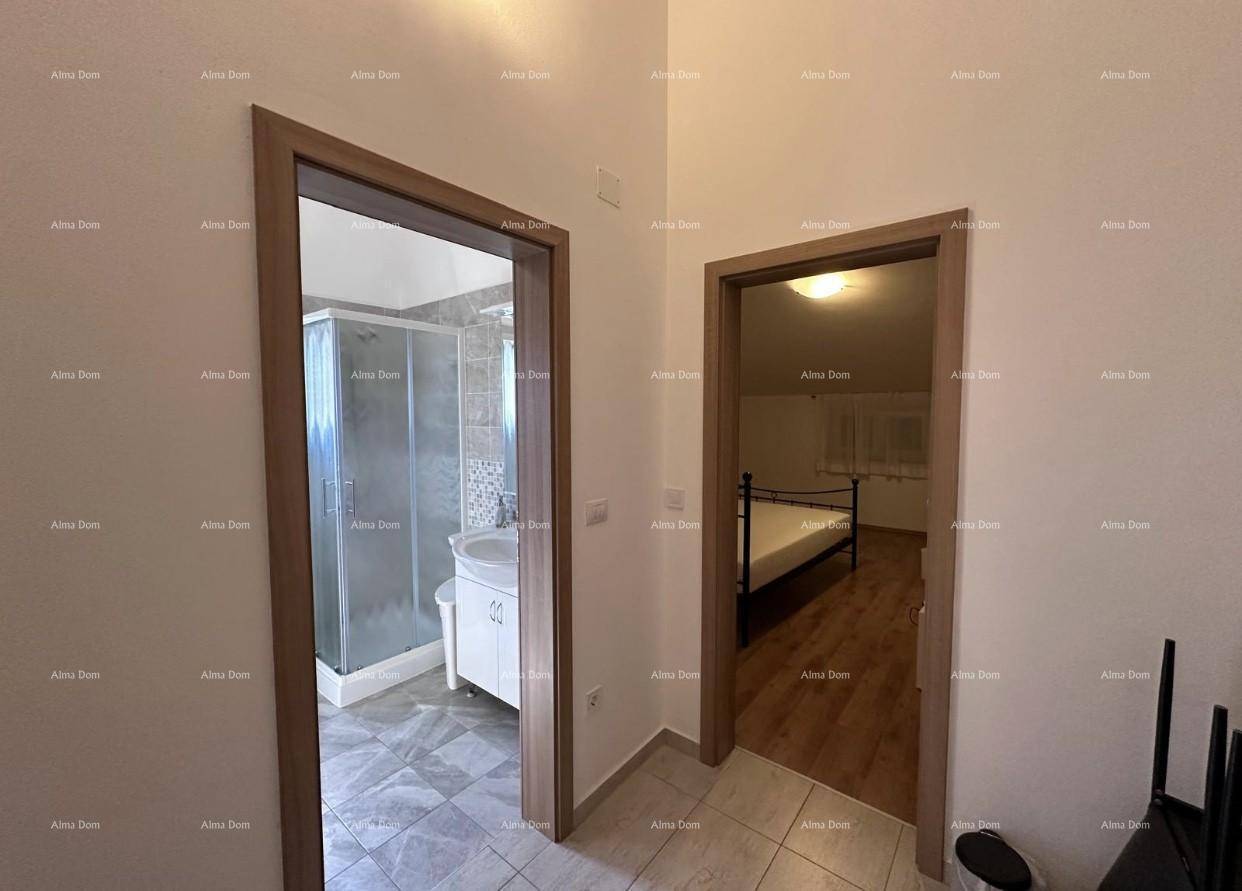 Heller Flur mit Zugang zu einem Badezimmer mit Dusche und einem Schlafzimmer.