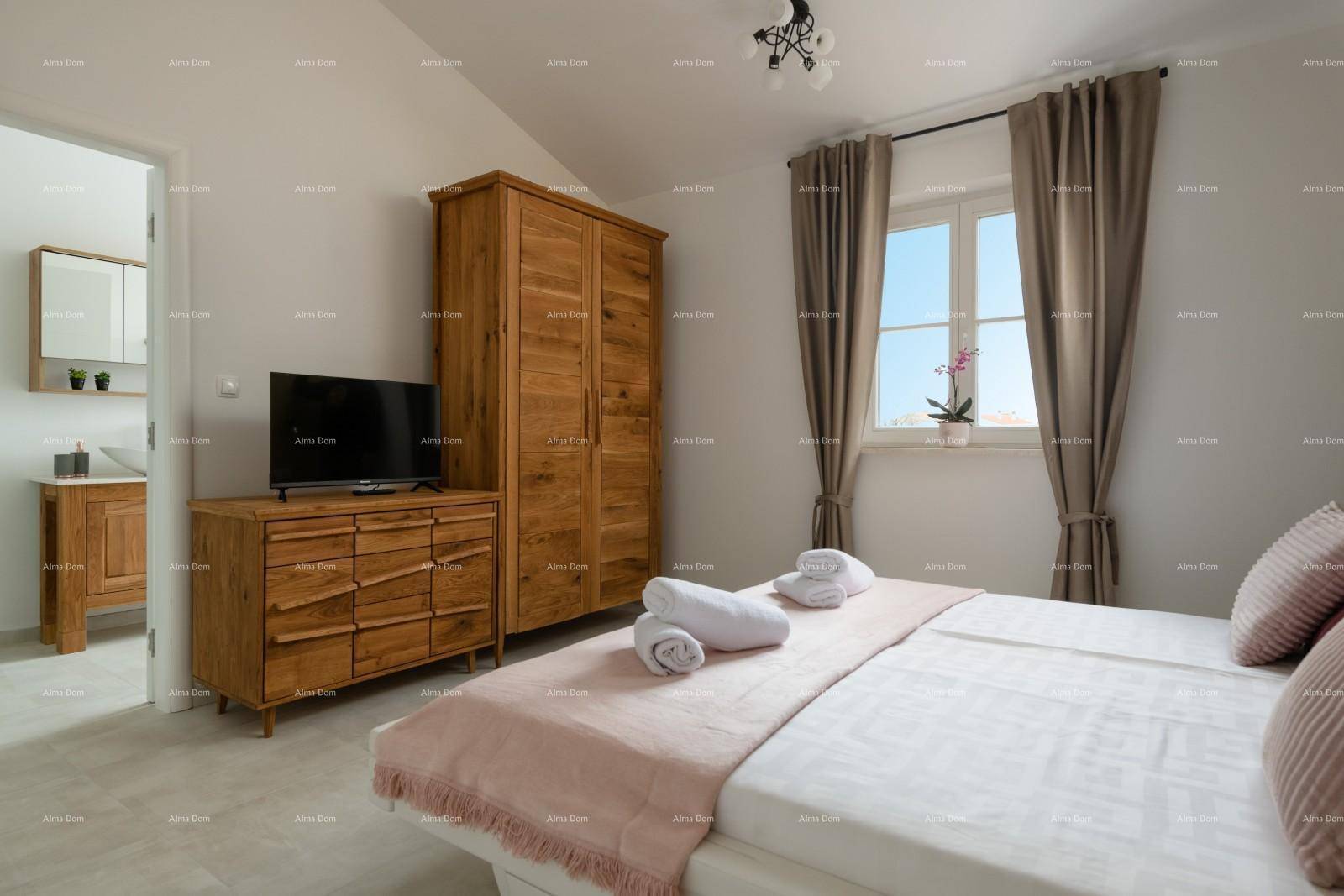Gemütliches Schlafzimmer mit Holzbett, Kleiderschrank und Zugang zum angrenzenden Badezimmer.