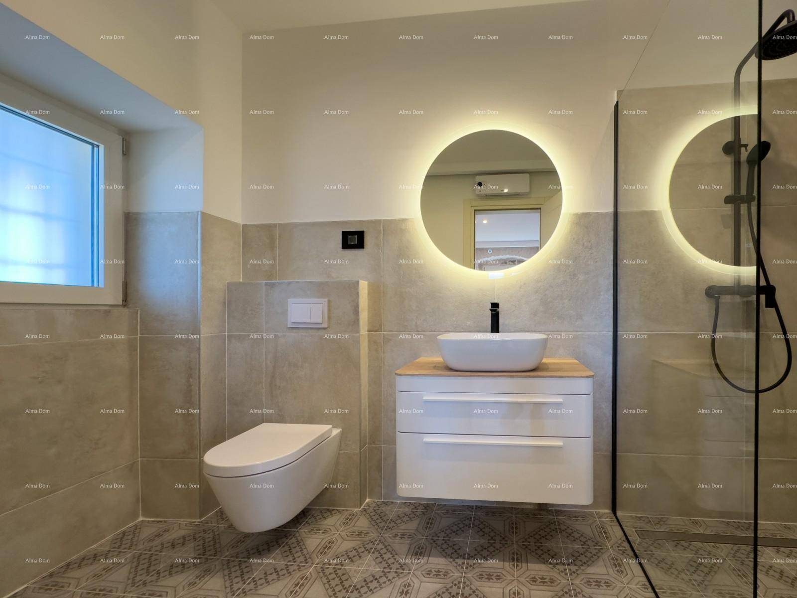 Modernes Badezimmer mit beleuchtetem Spiegel, Hänge-WC und ebenerdiger Dusche.