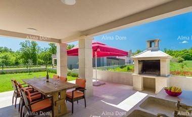 Überdachte Terrasse mit großem Esstisch, Stühlen und integriertem Grillbereich für Mahlzeiten im Freien.