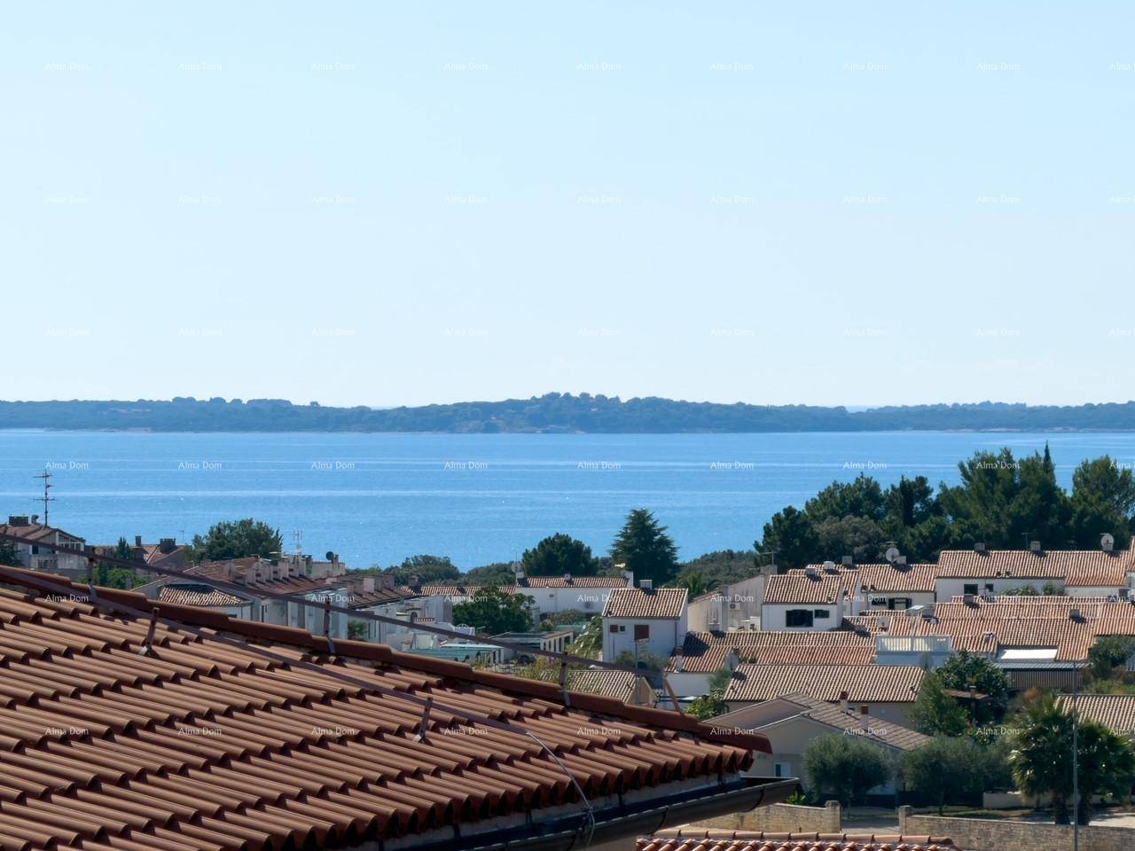 Panoramablick auf das Meer und die umliegende Küstenlandschaft mit roten Dächern der Häuser.