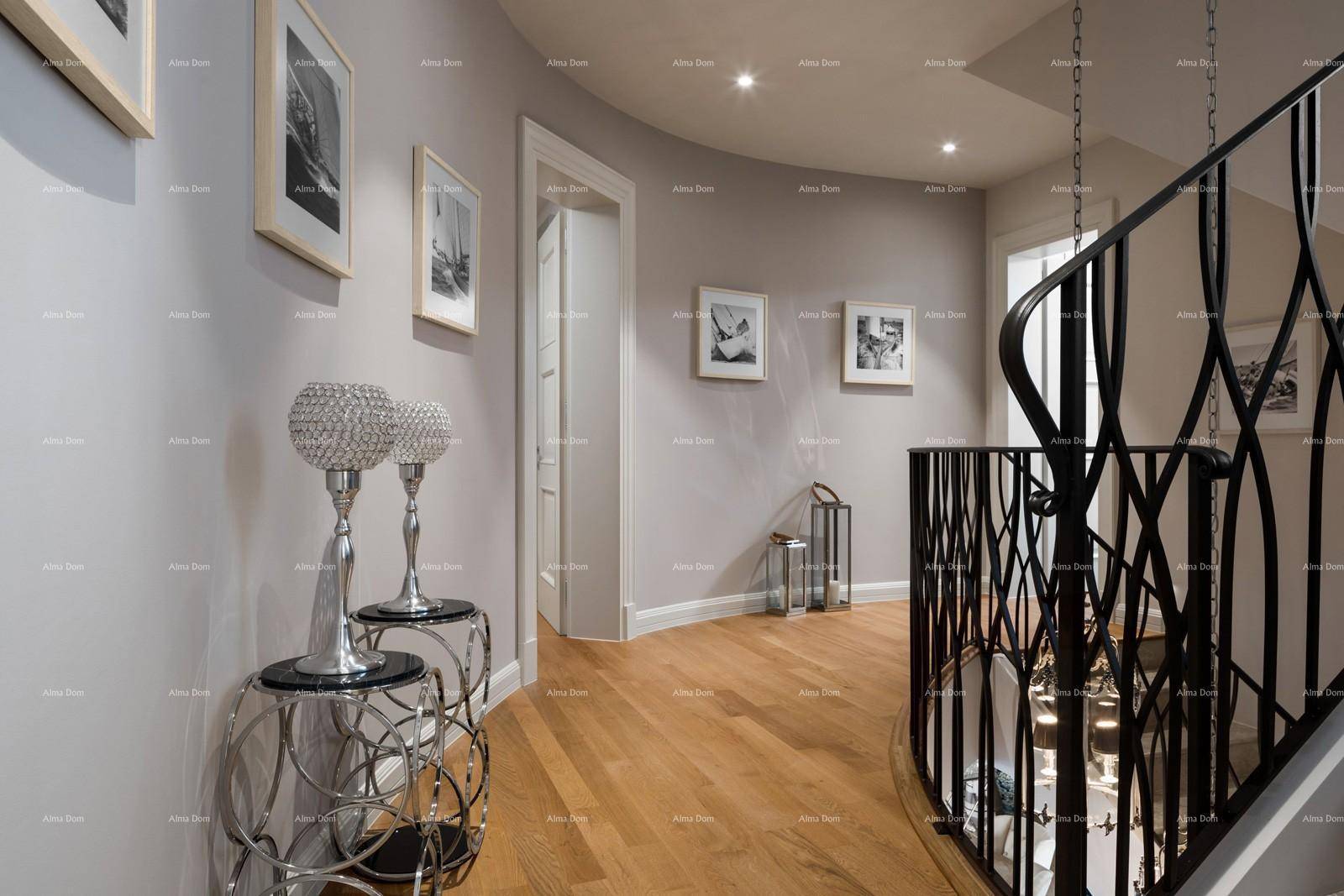 Eleganter Flur mit geschwungener Treppe, Holzboden und stilvollen Dekorationen.