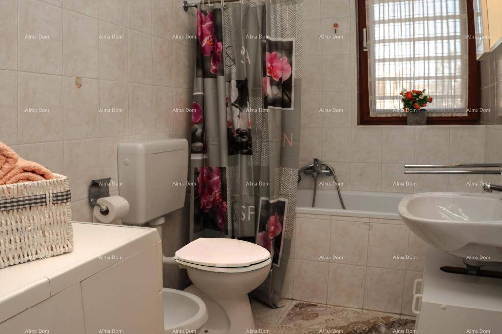 Gefliestes Badezimmer mit Badewanne, Dusche, WC, Bidet und einem Fenster für Tageslicht.