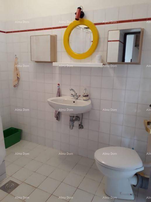 Kleines WC mit Waschbecken, Toilette und einem runden gelben Spiegel.