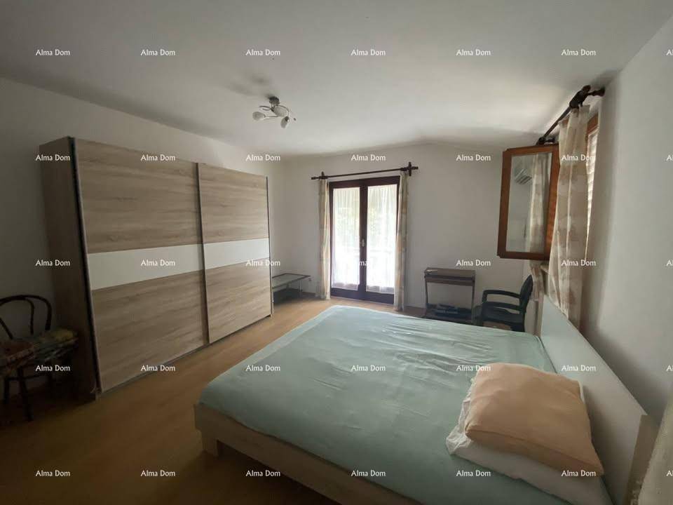 Schlafzimmer mit großem Kleiderschrank, Doppelbett und Zugang zu einem Balkon.