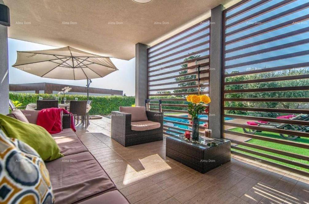 Gemütlicher überdachter Loungebereich auf der Terrasse mit Rattanmöbeln und Blick auf den Pool.