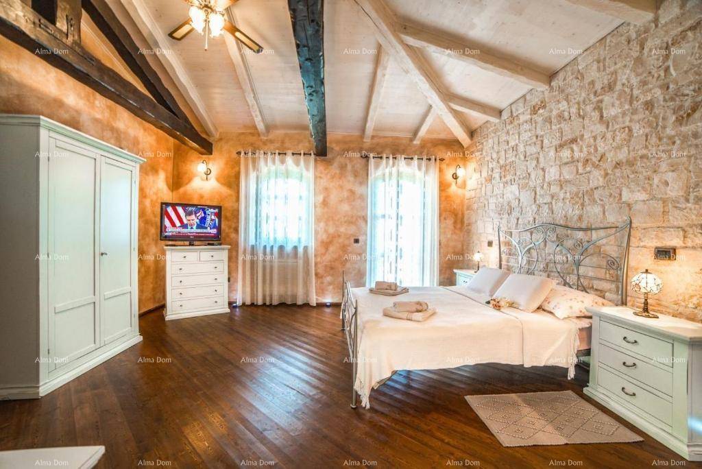 Helles Schlafzimmer mit hohen, gewölbten Decken, Holzboden und einer markanten Steinwand.