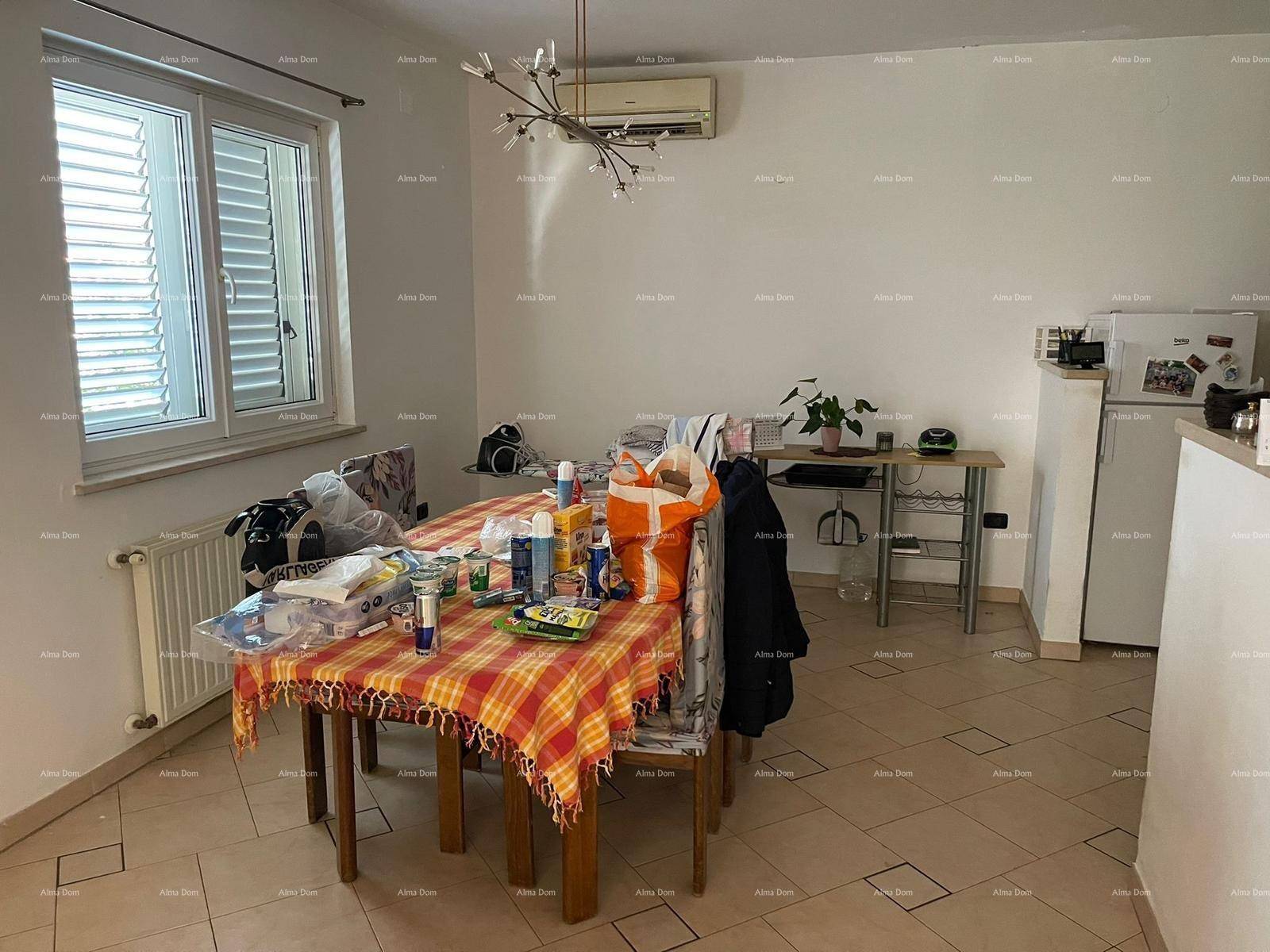 Essbereich mit großem Tisch, Fliesenboden und Klimaanlage an der Decke.