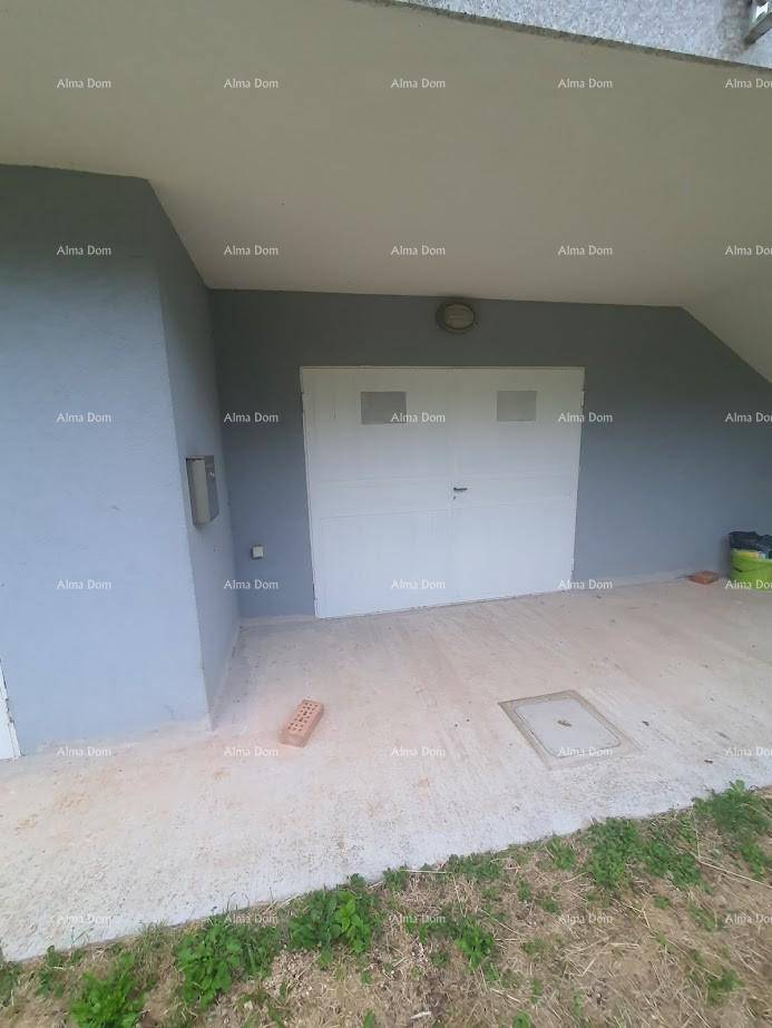 Außenseite der Garage mit weißem Tor und grau gestrichener Wand.