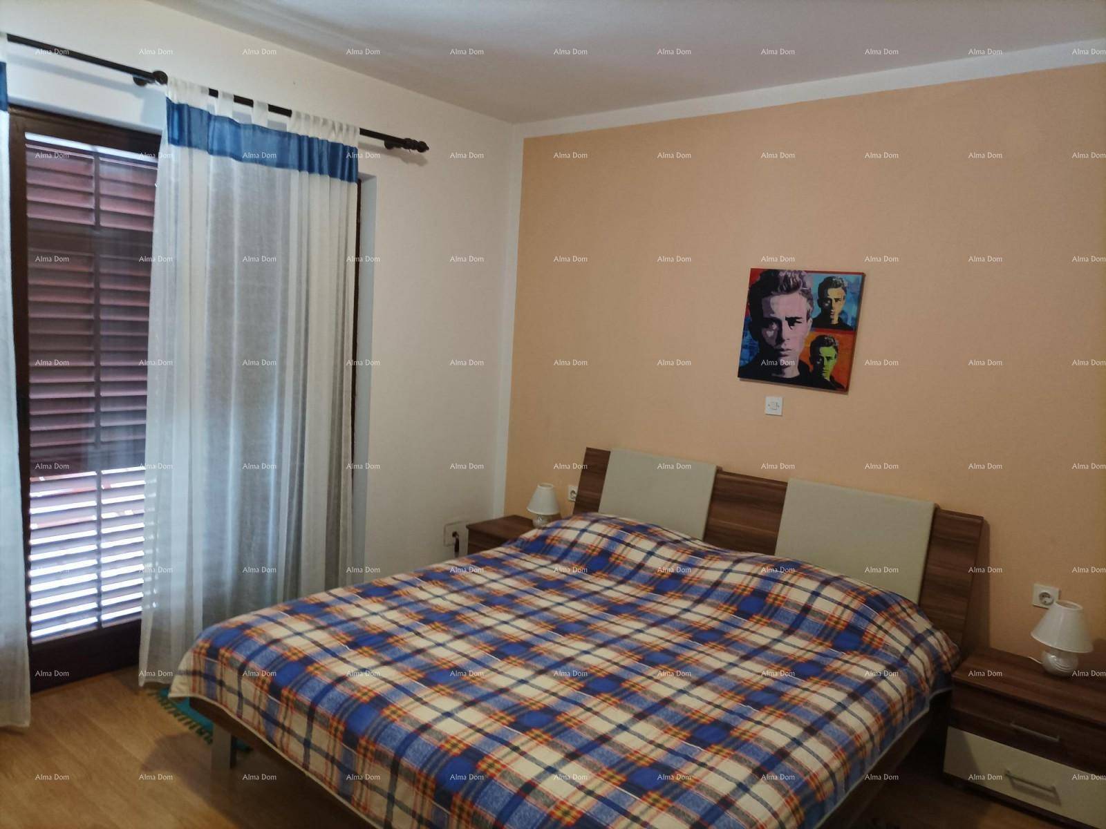 Schlafzimmer mit Doppelbett, Nachttischen und einem Fenster mit Vorhängen und Fensterläden.