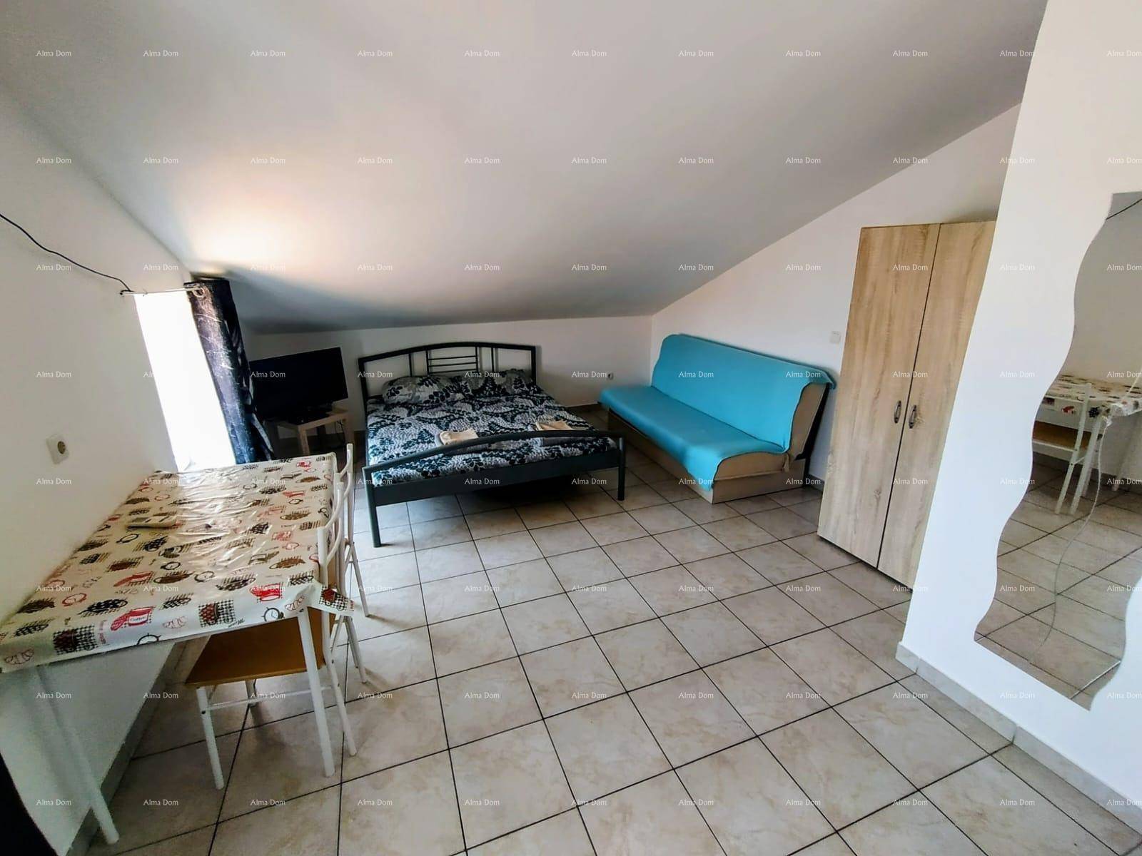 Geräumiges Studio-Apartment mit Bett, Schlafsofa und Essbereich, mit Fliesenboden.
