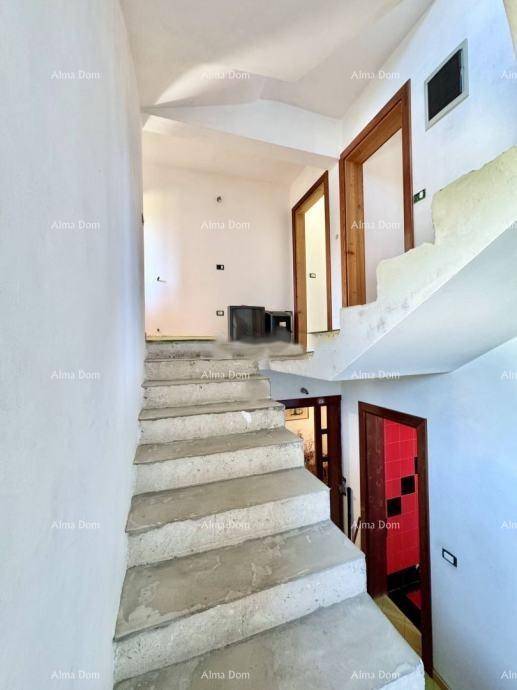 Treppenhaus mit rohen Betonstufen und Zugang zu verschiedenen Räumen im Obergeschoss.