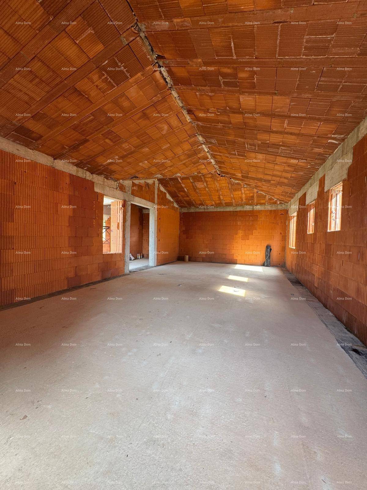 Innenraum im Rohbau mit Ziegelwänden, Betonboden und sichtbarer Holzdeckenkonstruktion, hell beleuchtet.