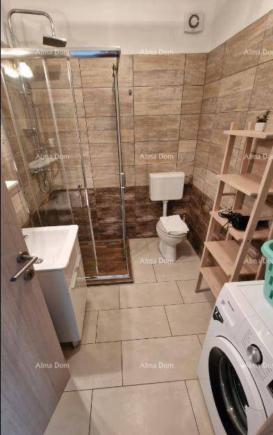 Funktionales Badezimmer mit Duschkabine, WC, Waschbecken und integrierter Waschmaschine.