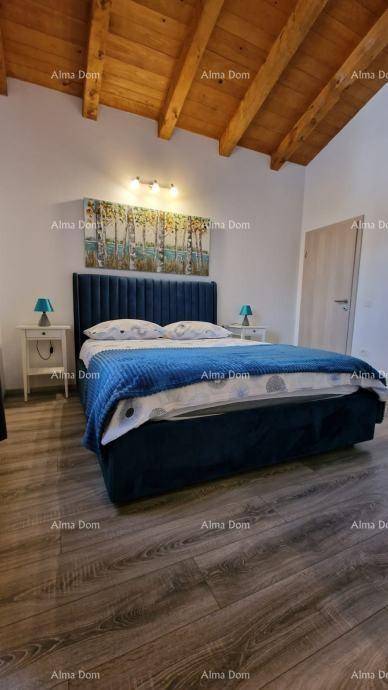 Geräumiges Schlafzimmer mit Doppelbett, Nachttischen und einer beeindruckenden Holzbalkendecke.