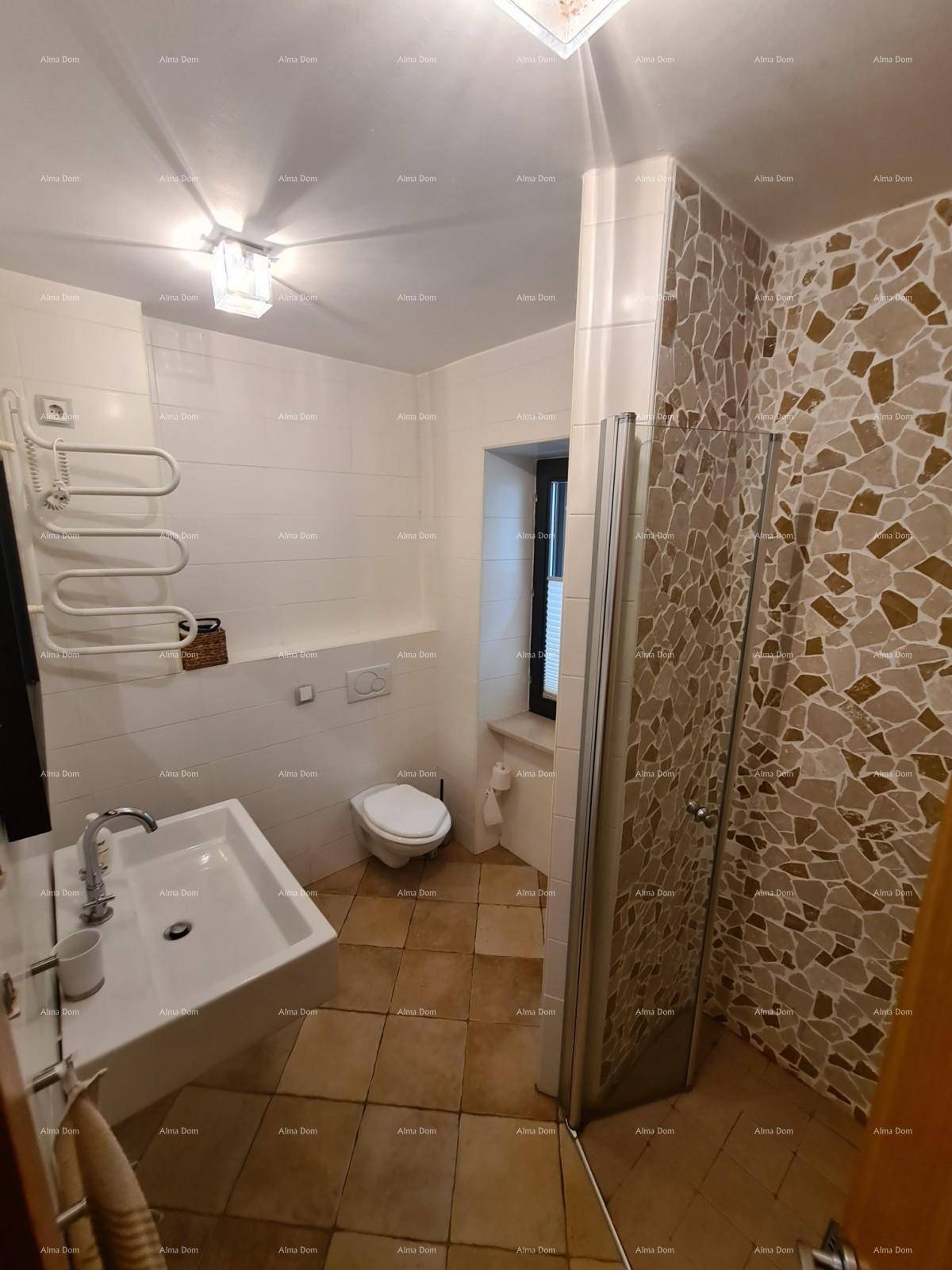 Modernes Badezimmer mit Dusche, WC, Waschbecken und Fenster, hell gefliest.