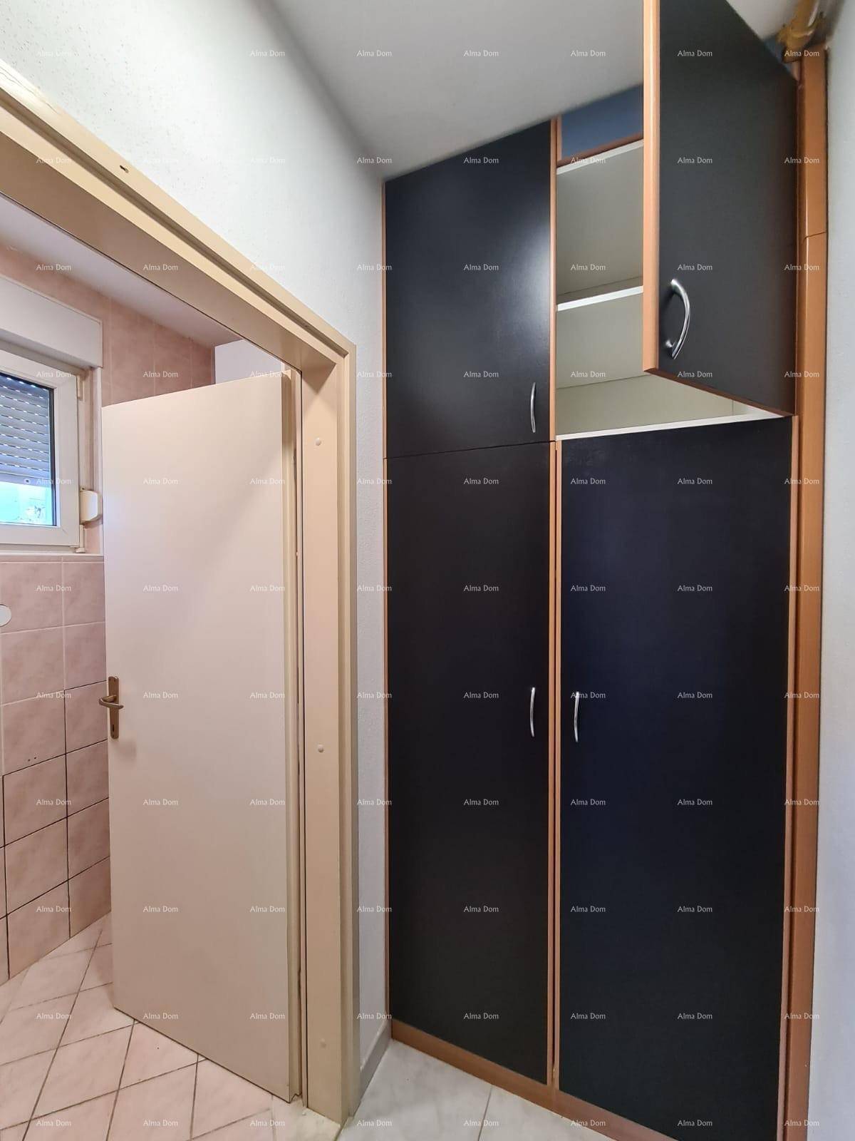 Flur mit Einbauschränken und Zugang zu einem Badezimmer.