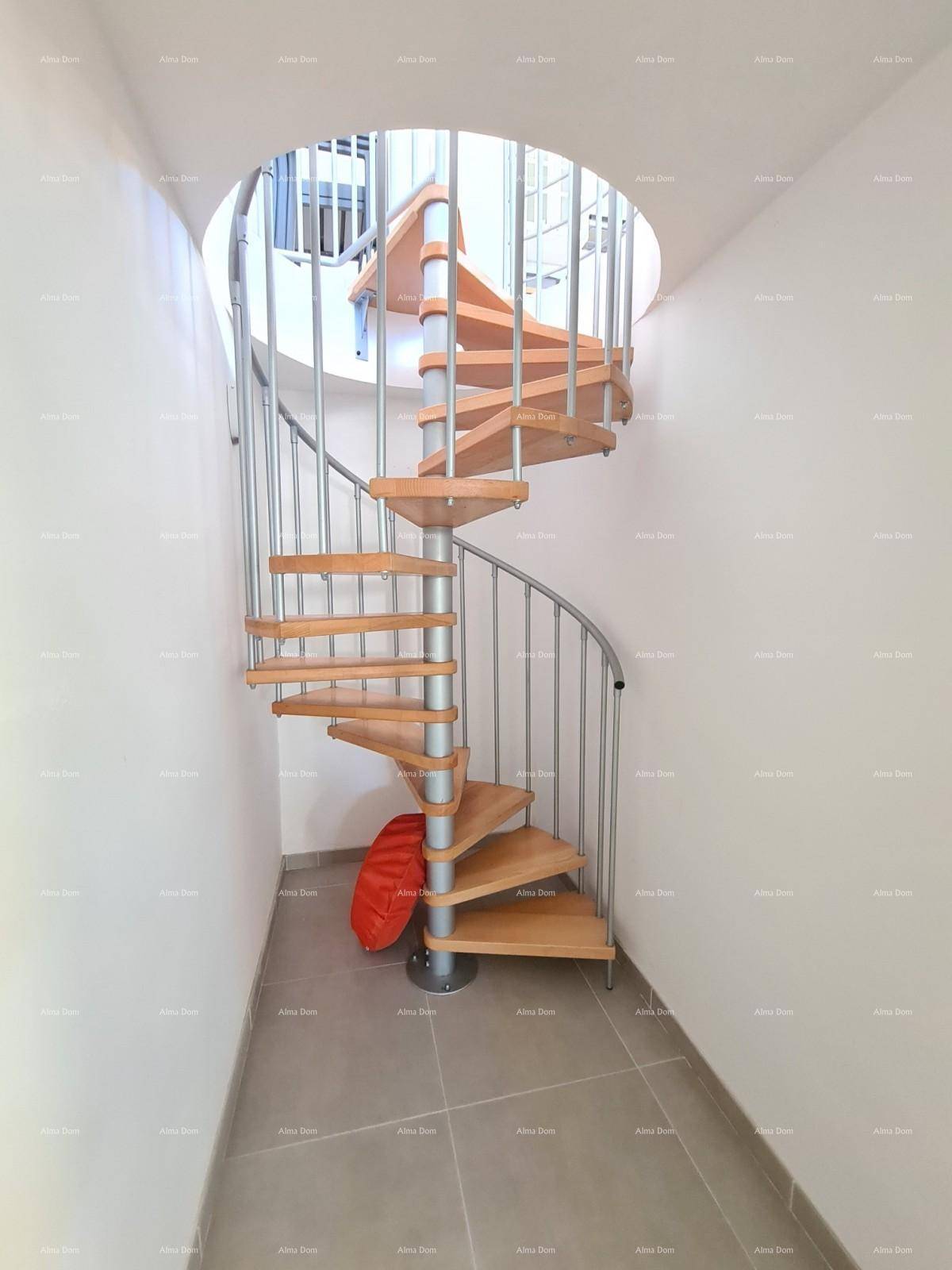 Elegante Wendeltreppe aus Holz und Metall, die die Etagen verbindet.