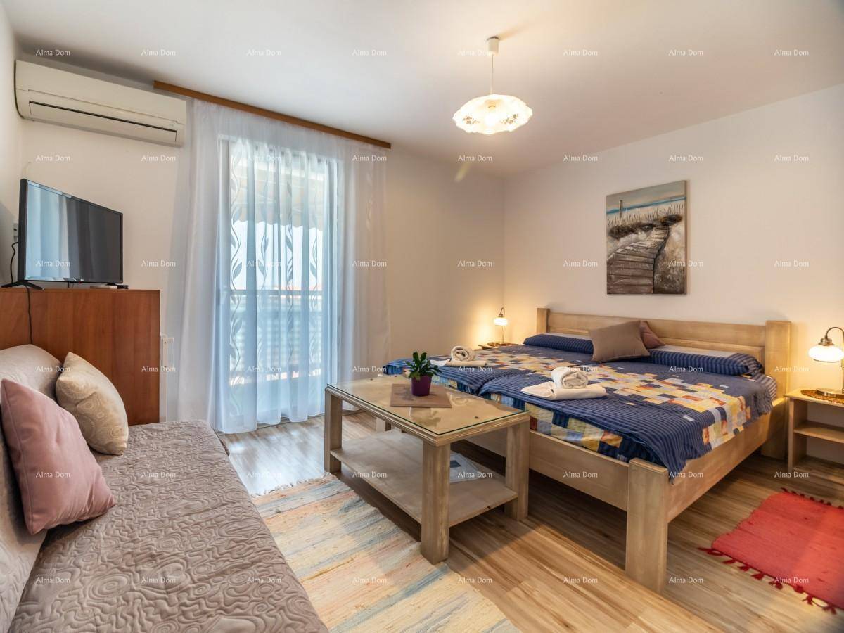 Schlafzimmer mit zwei Einzelbetten, Sofa, Fernseher, Klimaanlage und Balkonzugang.