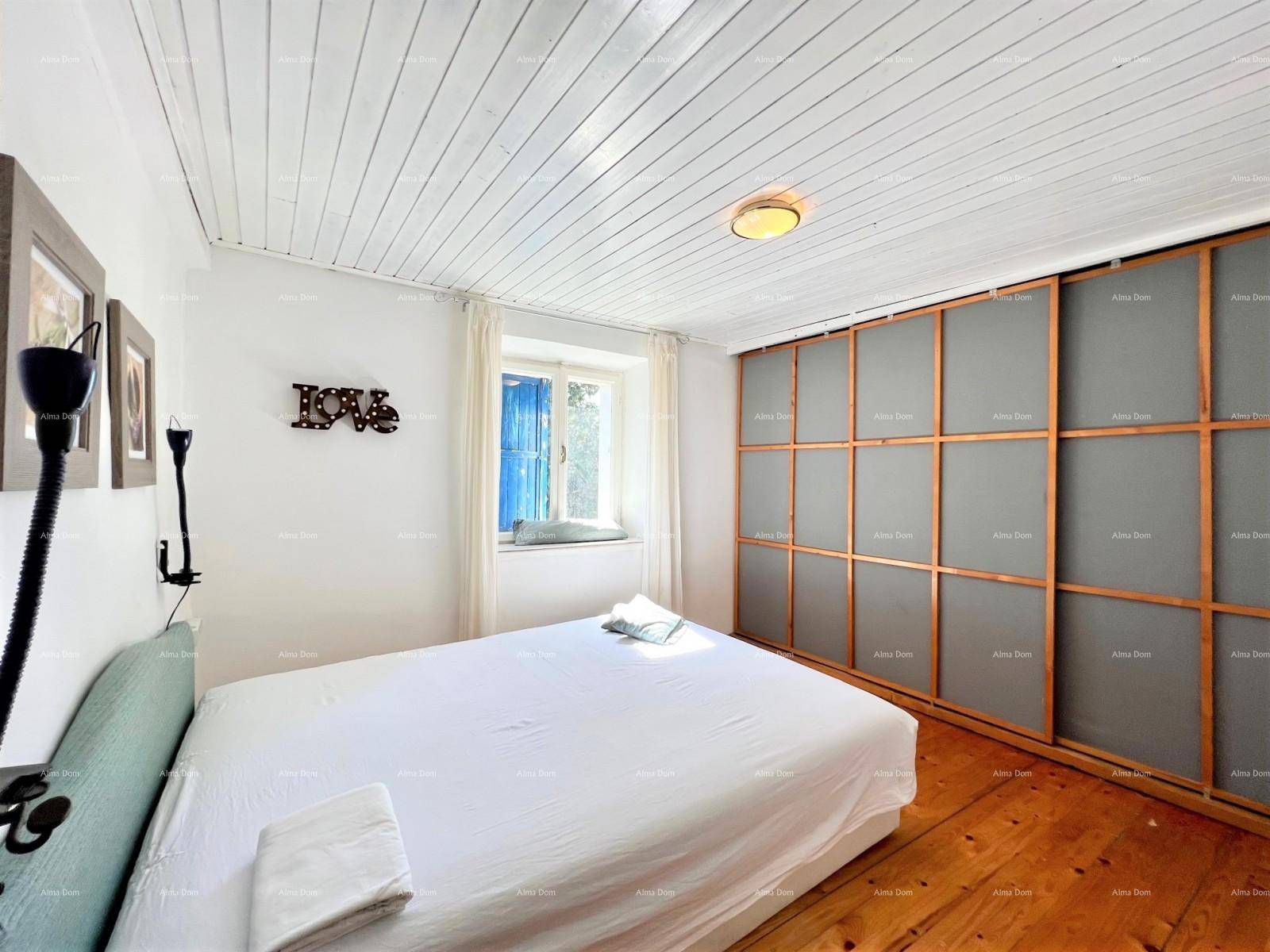 Schlafzimmer mit Holzdielenboden, weißer Holzdecke und einem großen Einbauschrank.