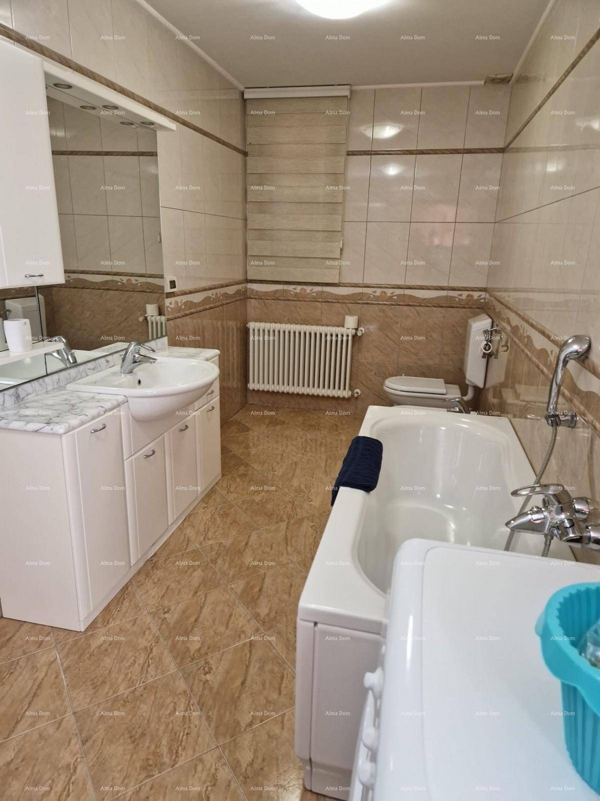 Badezimmer mit Badewanne, Waschbecken, WC und Fliesen an Wänden und Boden.