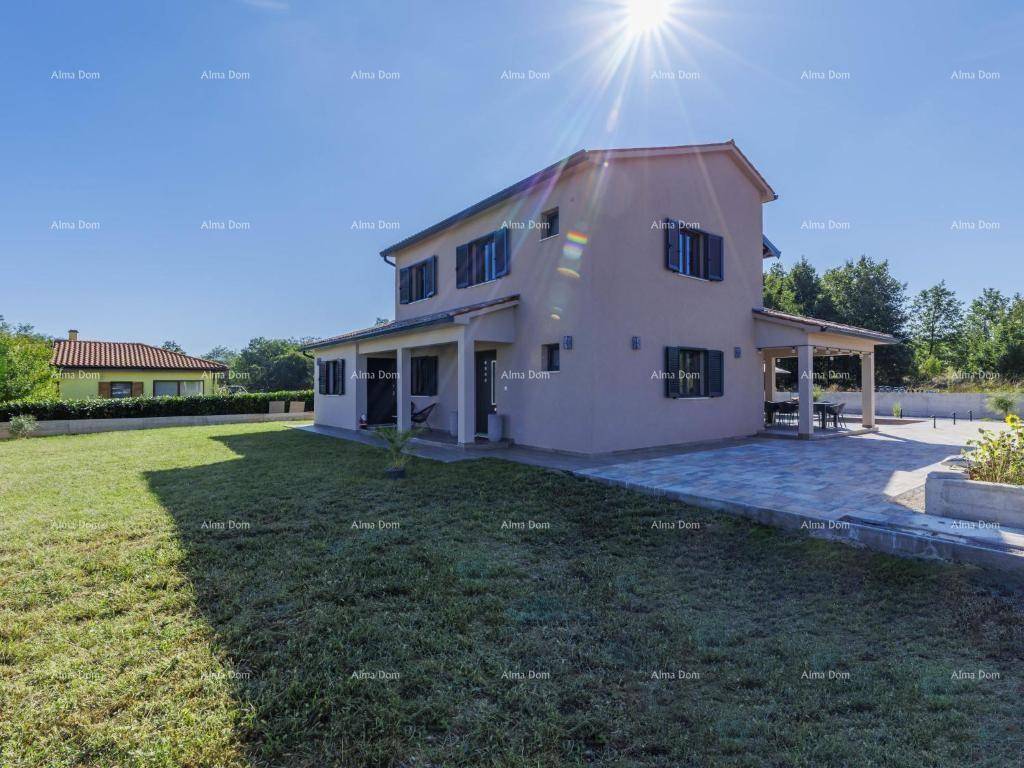 Sonniges Einfamilienhaus mit großem Garten, Rasenfläche und moderner Architektur.