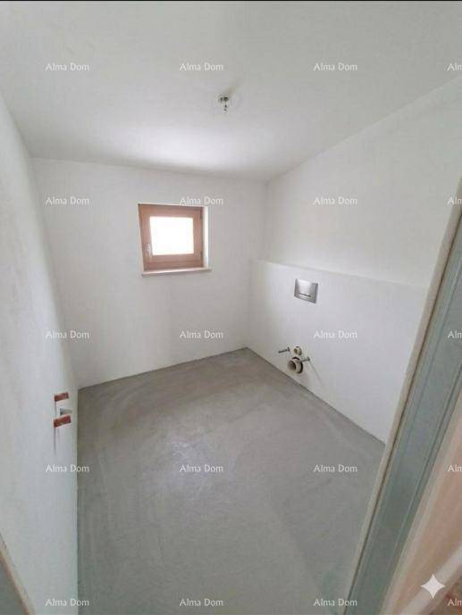 Unmöbliertes Badezimmer mit Fenster und sichtbaren Sanitäranschlüssen, bereit für den Ausbau.