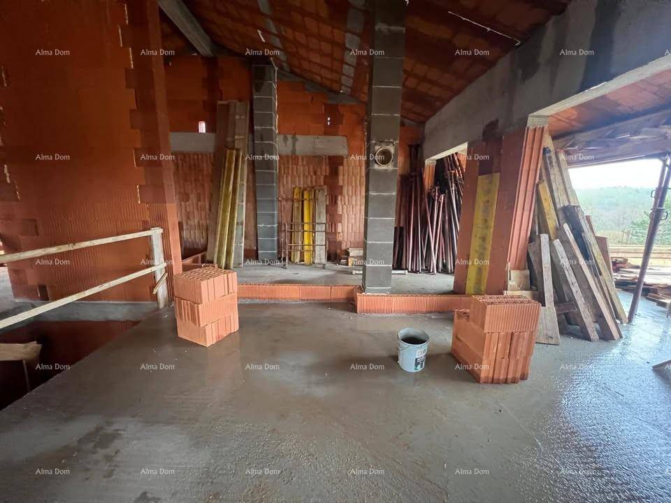 Innenansicht eines Raumes im Rohbau mit Ziegelwänden, Betonboden und Baustützen.