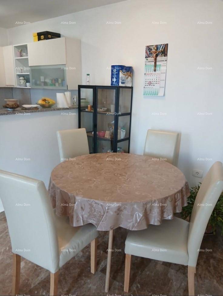 Heller Essbereich mit rundem Tisch und Stühlen, angrenzend an eine einfache Küchenzeile.