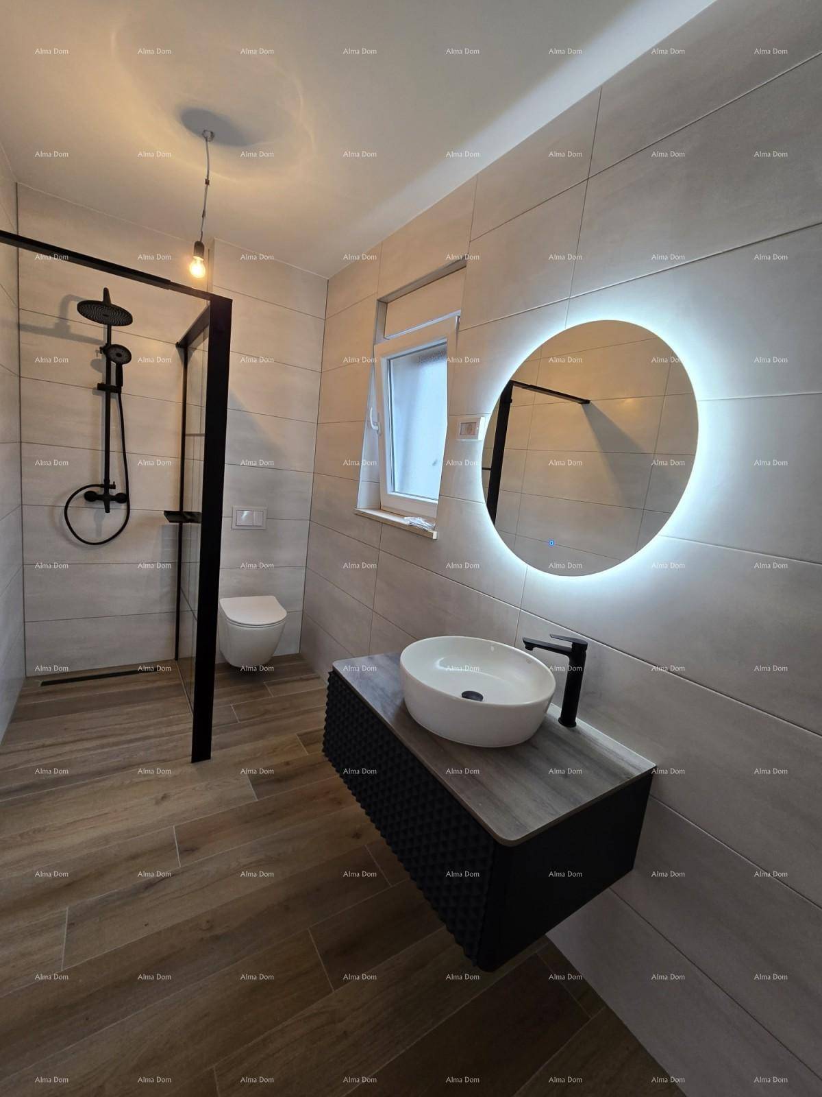 Elegantes Badezimmer mit runder Spiegelleuchte, Hänge-WC und dunklen Armaturen.