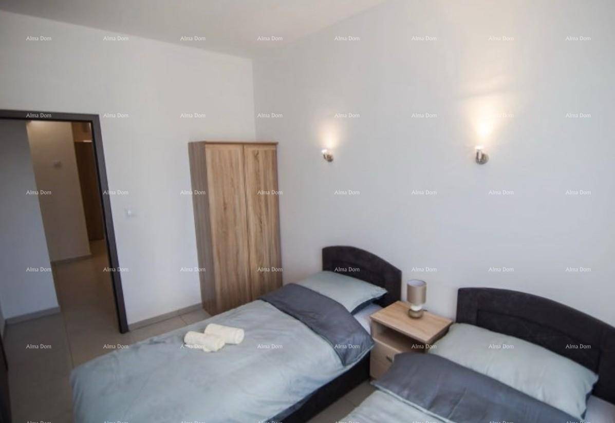Schlafzimmer mit zwei Einzelbetten, Holzschrank und indirekter Beleuchtung durch Wandlampen.