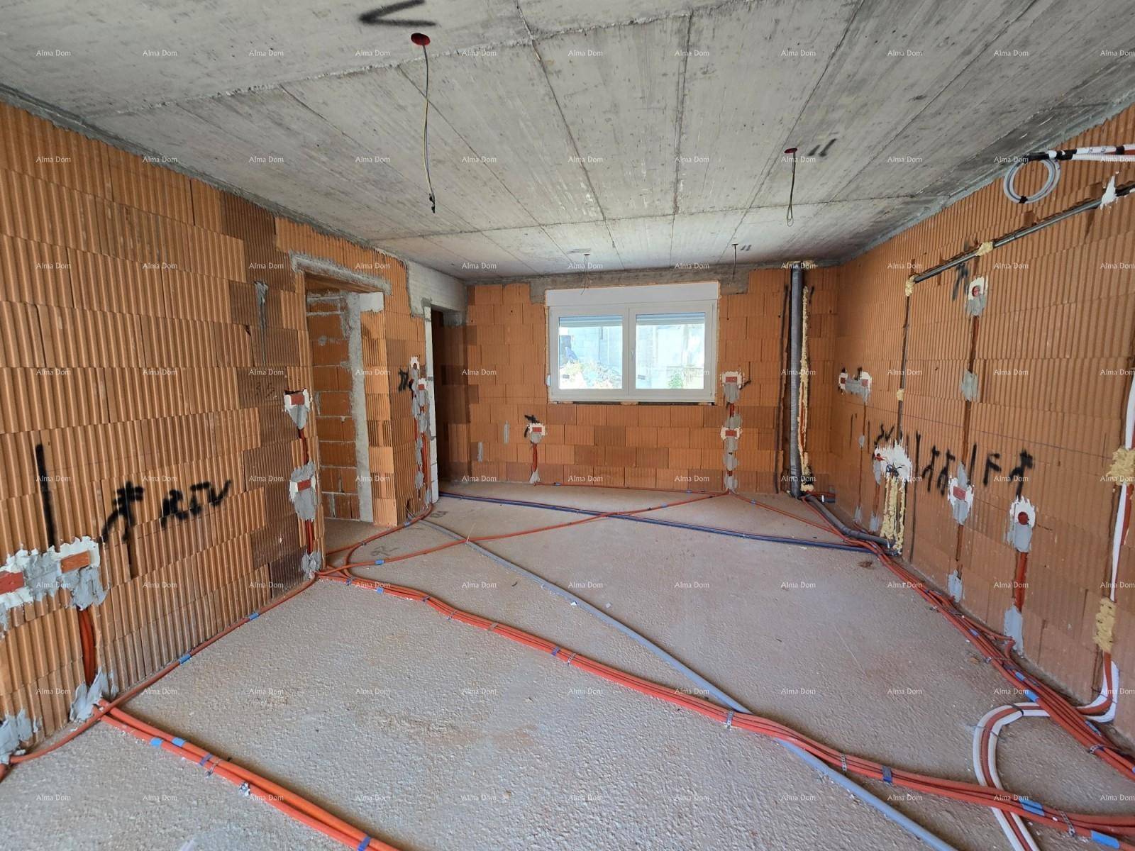 Rohbau eines Zimmers mit Fenster, unverputzten Ziegelwänden und vorbereiteten Elektroinstallationen.