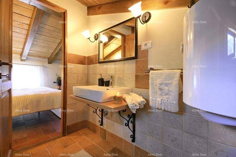 Badezimmer mit Einzelwaschbecken, Spiegel und gemusterten Fliesen.