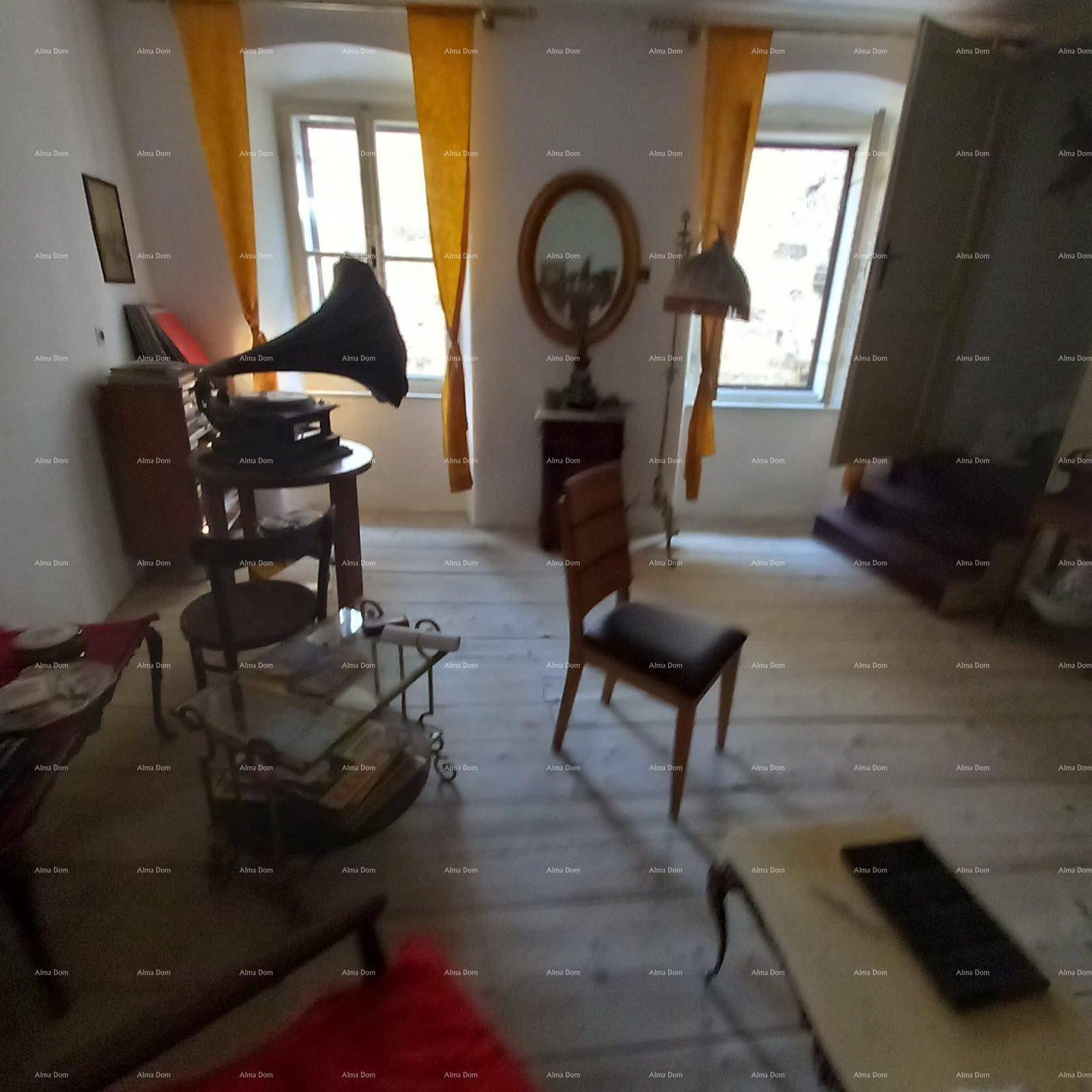 Geräumiges Wohnzimmer mit Holzdielenboden, Vintage-Möbeln und gelben Vorhängen.
