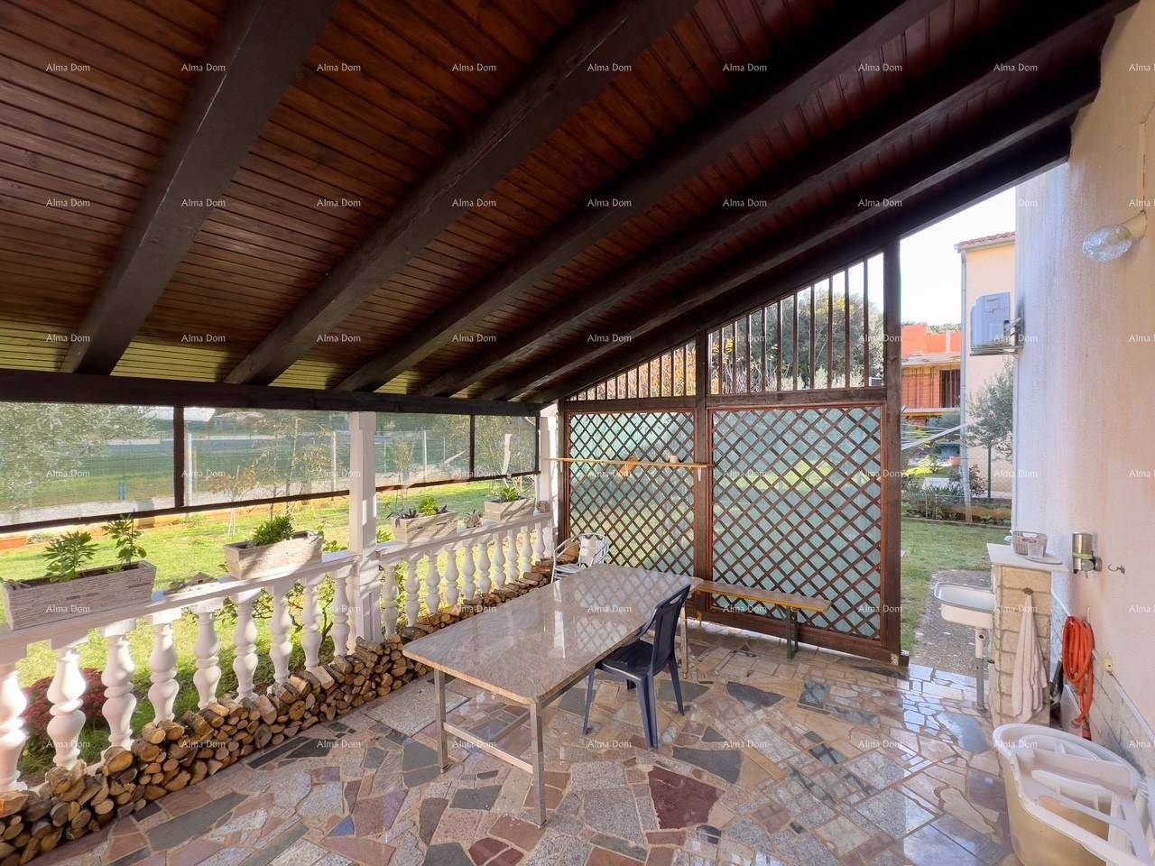 Überdachte Terrasse mit Esstisch, Holzbalkendecke und Blick auf den Garten.