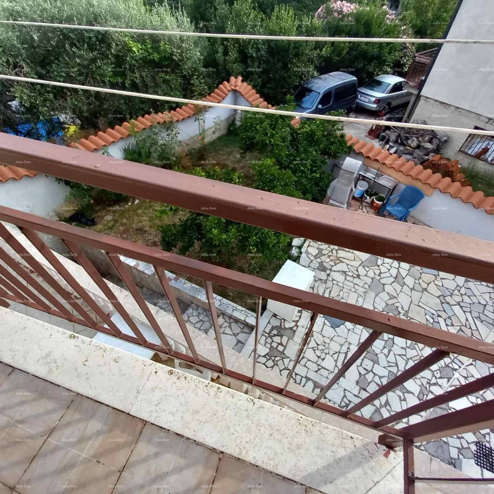 Blick von einem Balkon auf den Gartenbereich und die geparkten Autos in der Umgebung.