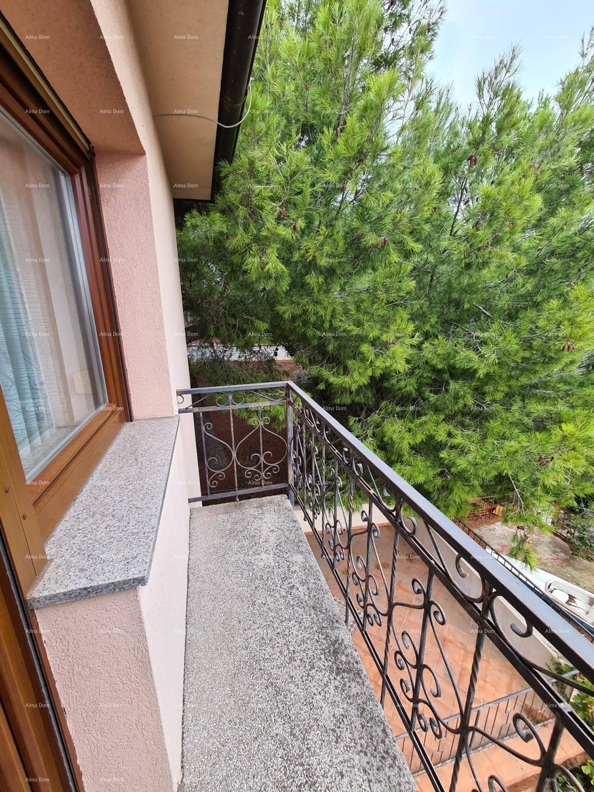 Kleiner Balkon mit schmiedeeisernem Geländer und Blick ins Grüne.
