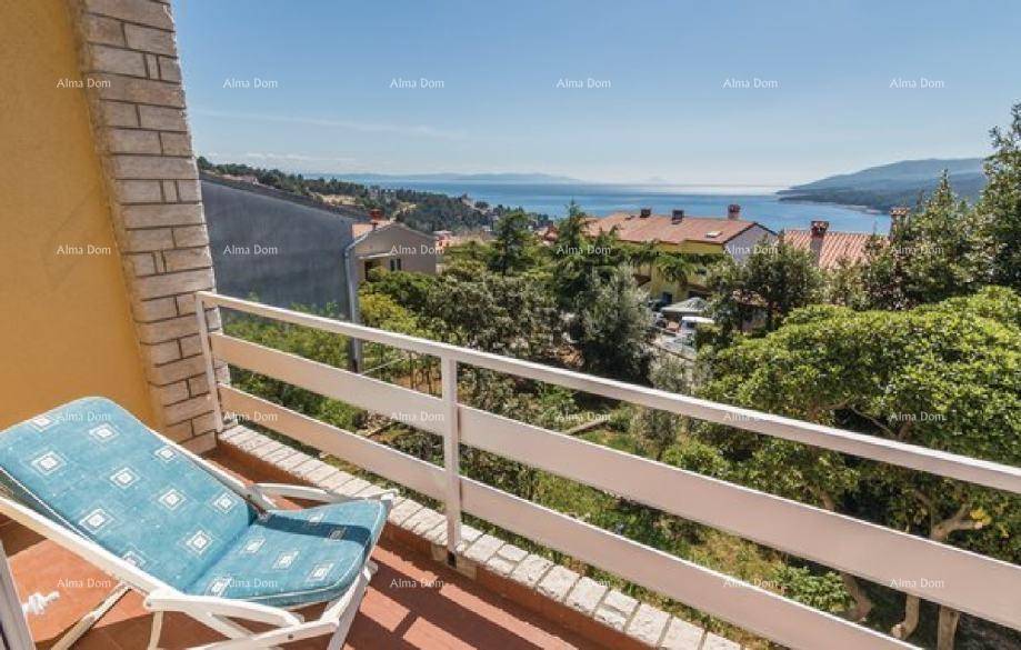 Balkon mit Liegestuhl und herrlichem Panoramablick auf das glitzernde Meer und die Küste.