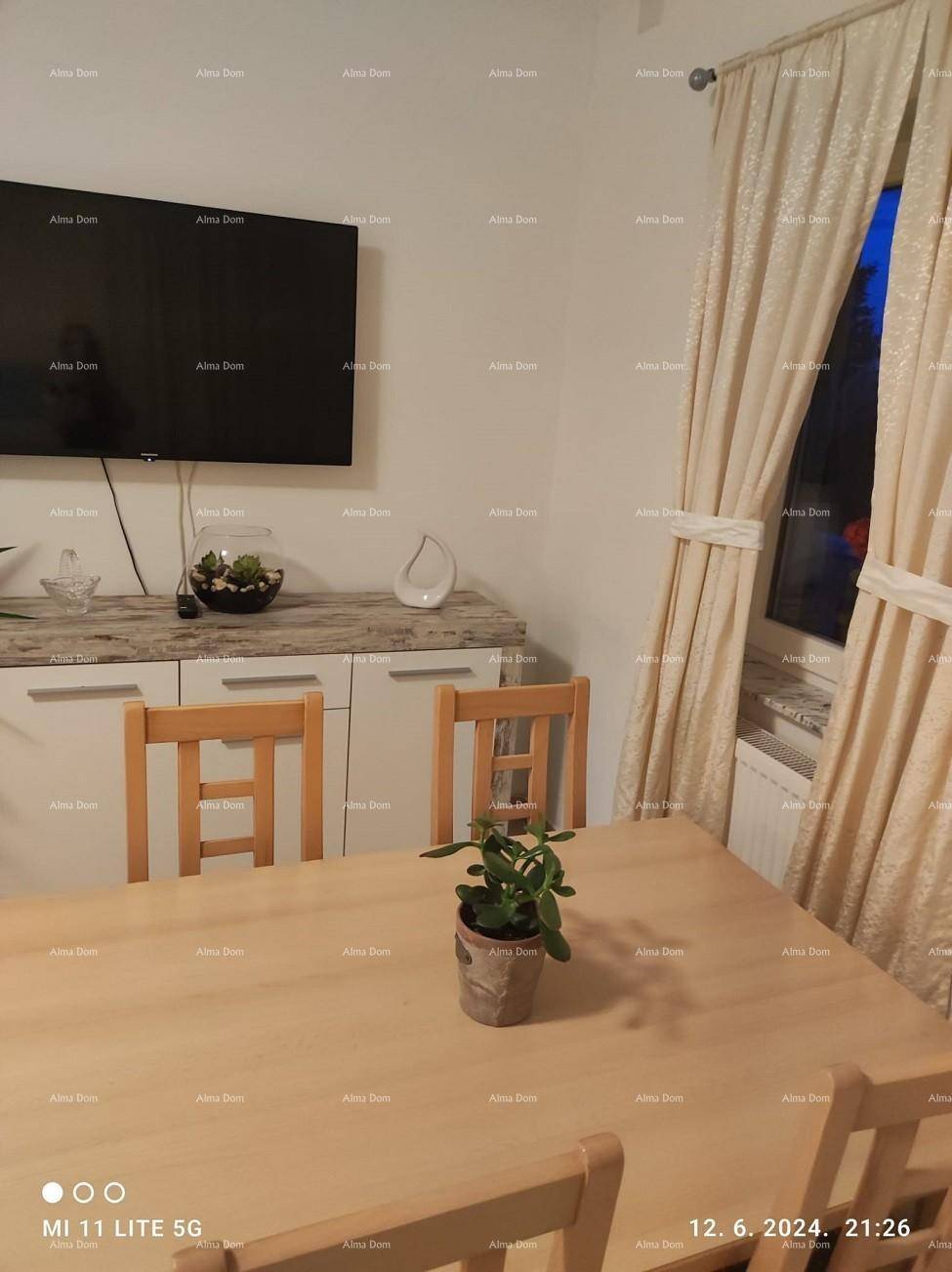 Essbereich mit Holztisch und Stühlen, daneben ein Sideboard mit Fernseher, hell und funktional.